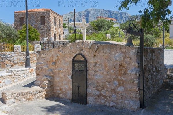 Rustic stone building in a Mediterranean landscape under a blue sky, Church of Agios Nikolaos,