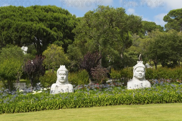 Two Buddha statues in a green, peaceful garden with numerous trees and bushes, Bacalhôa, Bacalhoa