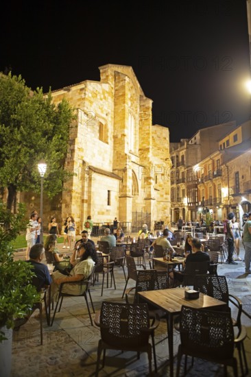 Restaurants on the Plaza Mayor at night, behind the Romanesque church Iglesia de San Juan de Puerta