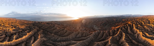 Panorama, landscape of eroded hills, badlands at sunset with Lake Issyk Kul, aerial view, Canyon of