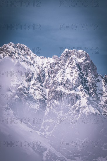 Majestic, snow-covered mountain peaks under a blue sky create a frosty atmosphere, Kaisergebierge,