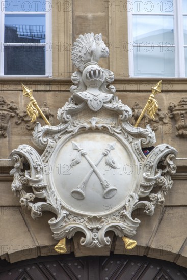 Two crossed halberds on the coat of arms of the Krackhardt merchant family above the entrance