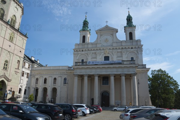 Large church with columned façade and parked cars in front, St John's Cathedral, Lublin, Poland,