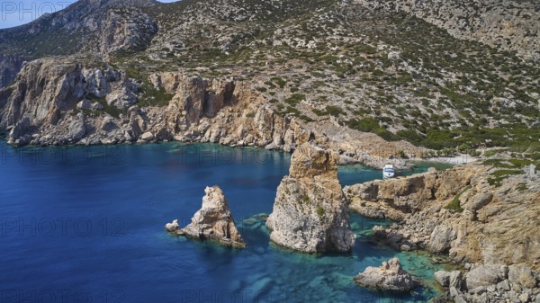 Palatia Beach, Palatia, cliff landscape with offshore rocks and a boat in the clear water, boat