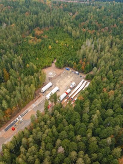Construction site in the forest with wind power components surrounded by colourful autumn leaves,