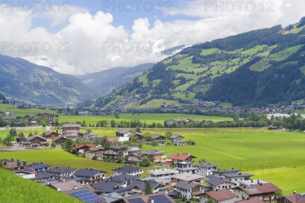 Alpine village with many houses and green hills, surrounded by majestic mountains, Mayrhofen,