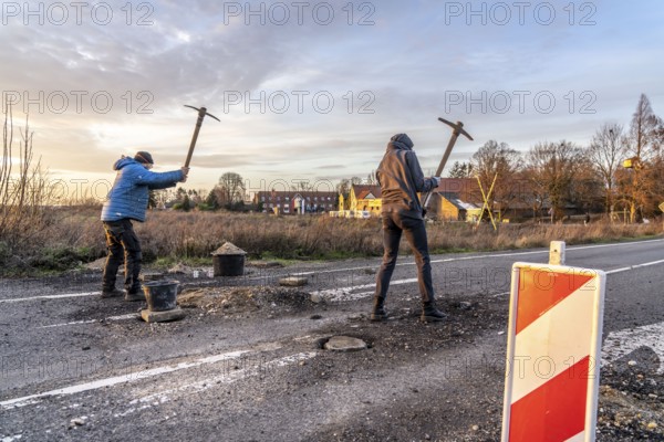 Climate activists chop up the asphalt of a road to erect obstacles, barricades, to prevent the