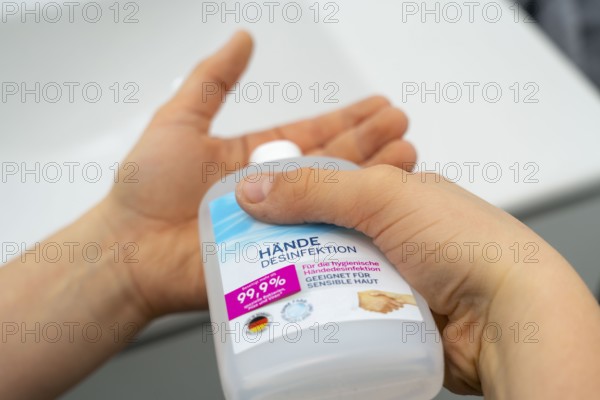 Domestic hygiene, sanitising hands with a hand sanitiser solution, boy 9 years old