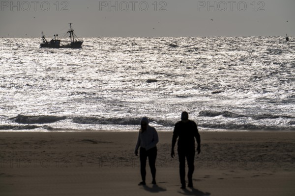 Strollers on the beach of Scheveningen, shrimp cutter, Netherlands