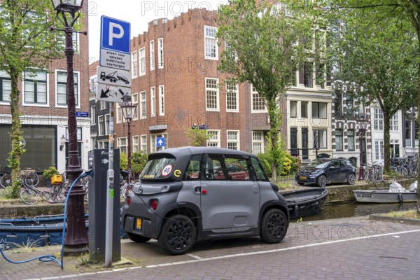 Mini car parked in the old town, Blauwburgwal canal, city centre of Amsterdam, Rocks Electric from