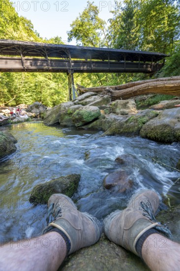 The Irrel Waterfalls, rapids in the lower reaches of the Prüm, covered wooden bridge for hikers,