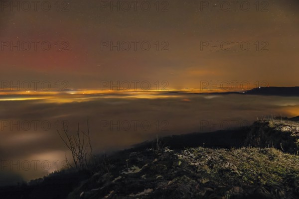 Firework lights under the sea of fog. New Year's Eve fireworks 2024 and a little red Aurora