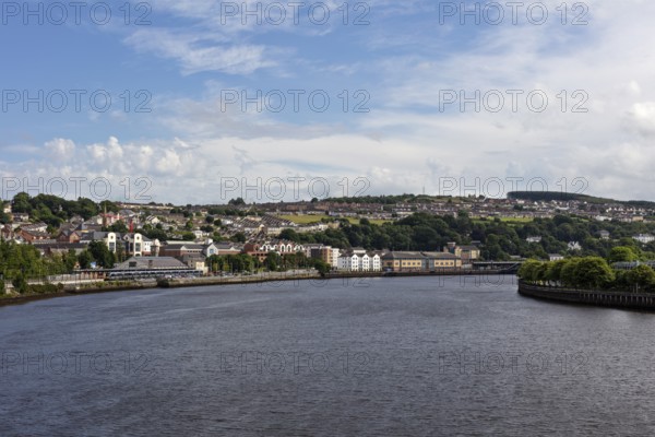 View over the river to the city with houses and blue sky, Londonderry