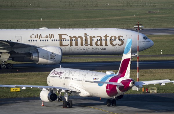 Düsseldorf Airport, Emirates Boeing 777 and Eurowings Airbus aircraft on the apron, taxiway, North