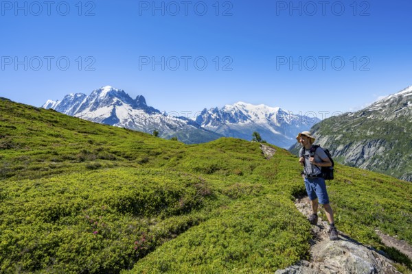 Mountaineer on hiking trail, mountain panorama with glaciated mountain peaks, Aiguille Verte with