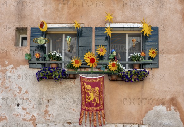 Windows decorated with flowers on a house facade, Venetian flag, Venice, Veneto, Italy, Europe