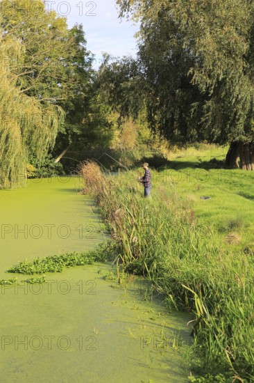 Autumn rural landscape River Deben, Ufford, Suffolk, England, UK with fisherman