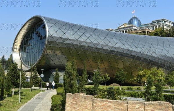 Futuristic theatre building and exhibition hall in Rike City Park, architect Studio Fuksas, behind