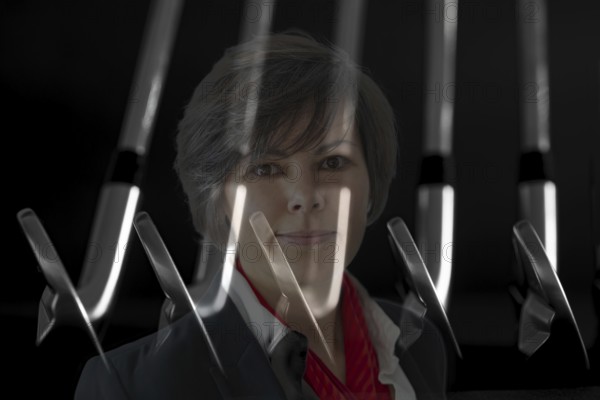 Business Woman and Golf Clubs Blades on Black Background in Switzerland