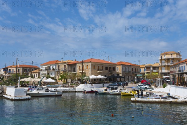 Harbour with boats and traditional buildings under a blue sky with some clouds, Agios Nikolaos,