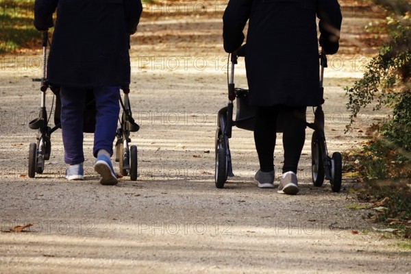 Senior citizens going for a walk with rollators, autumn, Germany, Europe
