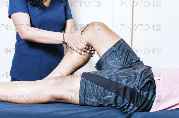 Physiotherapist woman checking patient's leg. Orthopedic specialist helping a patient with a leg