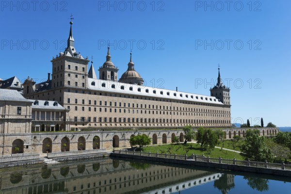 Historic stone monastery with reflection in the water and clear sky, Real Sitio de San Lorenzo de