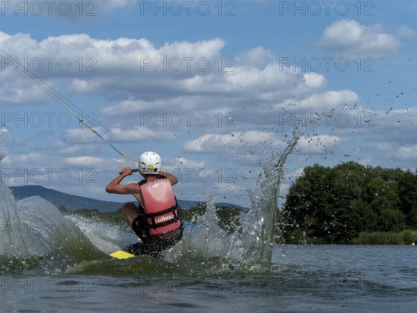 Young man jumping into the water with a wakeboard, Water ski and wake park, Water sports, Stráž pod
