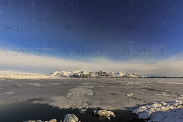 Night shot of an icy lake in front of Bergen, star trails, Vatnajökull, Jökulsarlon, Iceland,