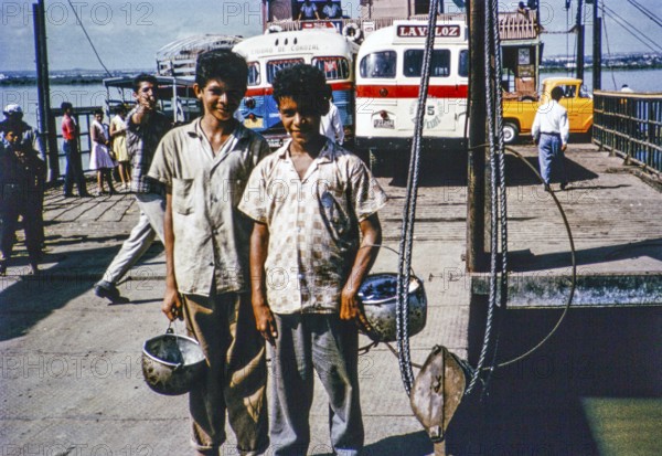 Two boys on board a car ferry crossing the Rio Magdalena river to Barranquilla, Colombia, South