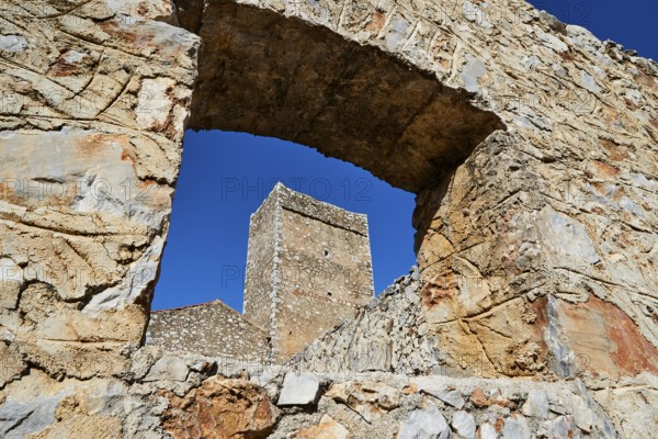 View through an arch of ruins to a clear sky and other stone structures, Flomochori, residential