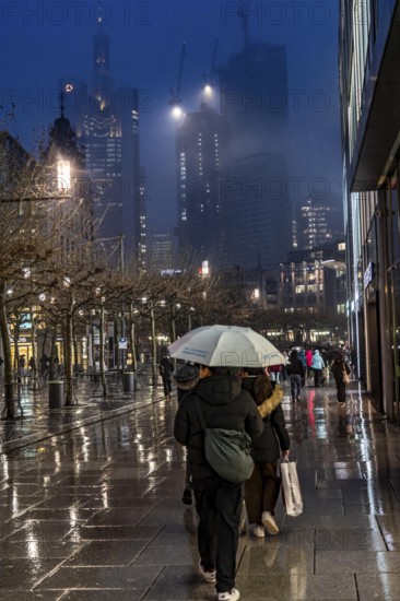 Rainy weather, freezing rain, pedestrian zone Zeil, shopping street, high-rise skyline in clouds,