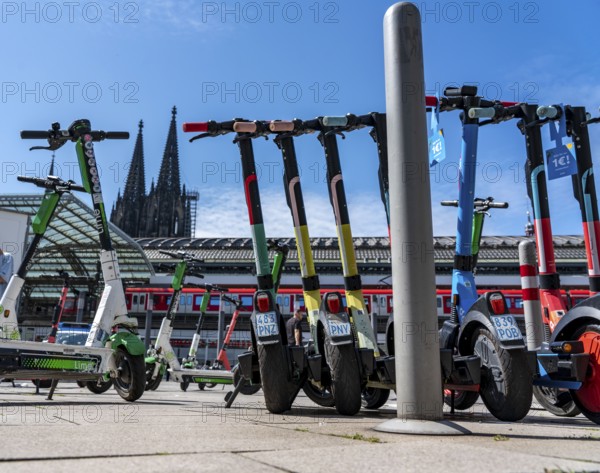 A large number of electric scooters are parked on Breslauer Platz, in front of Cologne Central