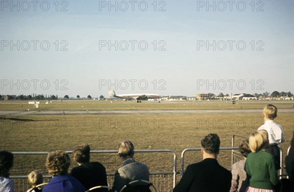 Aircraft spotters watching Lockheed Super Constellation aircraft on the runway, Heathrow Airport,