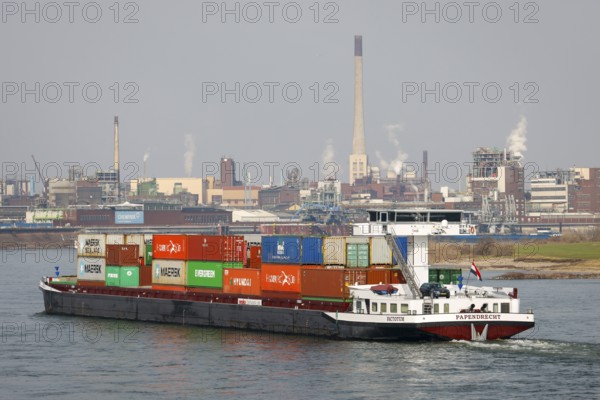 Krefeld, North Rhine-Westphalia, Germany - Cargo ship sails on the Rhine past the chemical plant