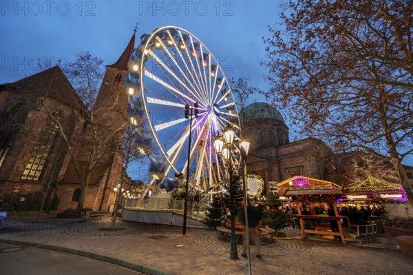 Ferris wheel at the winter village, Christmas market at dusk, St James' Church on the left, St