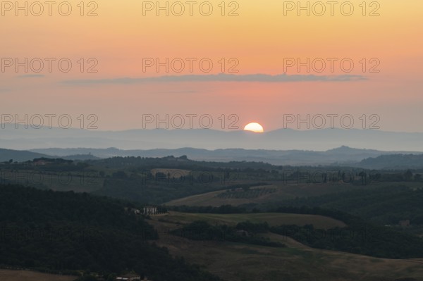 View from Montepulciano into a typical Tuscan landscape in Val d'Orcia with hills, trees, fields,