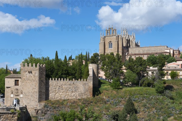 Medieval cityscape with church, city walls and trees under a blue sky with clouds, Puente de San