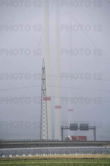 Wind farm in the fog, photovoltaic system, on the A44 motorway, dark doldrums, no wind no direct