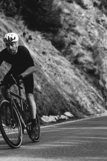 Road bike rider in spring in the Allgäu against the picturesque backdrop of the Alps, Bavaria,
