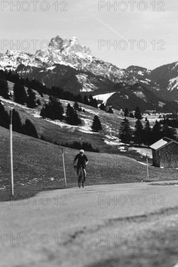 Road bike rider in spring in the Allgäu against the picturesque backdrop of the Alps, Bavaria,