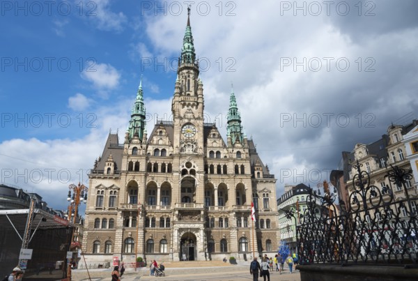 Gothic town hall with baroque architecture under a blue sky, people in the foreground, town hall,