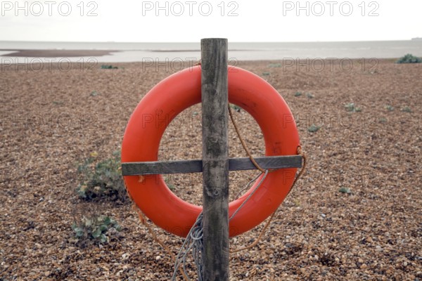 Red life saving ring Shingle Street beach, Suffolk, England, UK