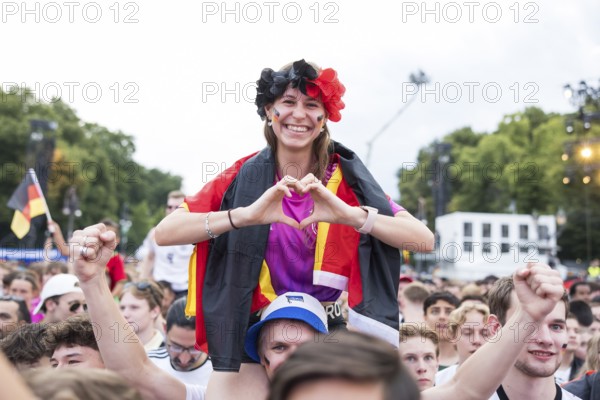 Celinda forms a heart with her hands in the fan zone at the Brandenburg Tor during the round of 16