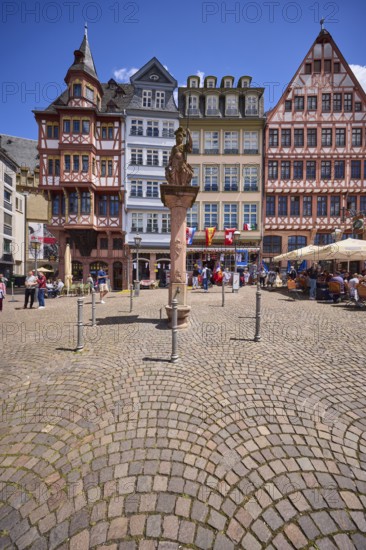 Minerva fountain with half-timbered houses on the Römerberg town hall square under a blue sky with