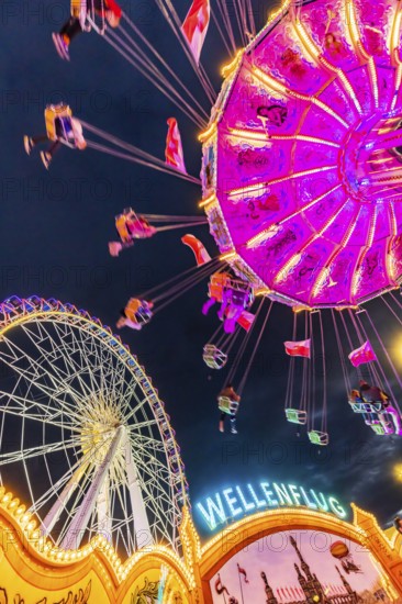 Chain carousel and Ferris wheel in the evening. 177th Cannstatter Volksfest at the Cannstatter