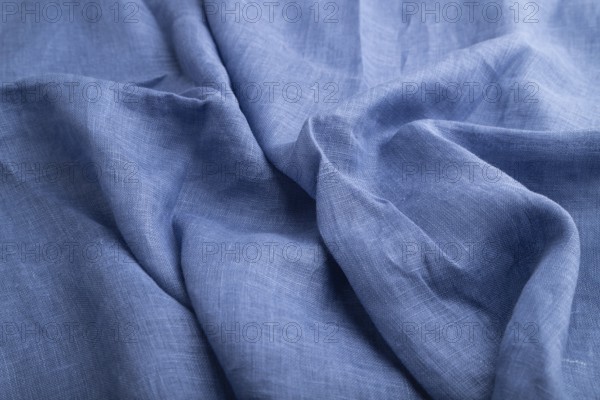 Fragment of blue linen tissue. Side view, natural textile background and texture. wave concept,