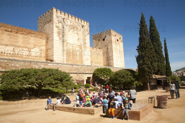 Fortified walls of the Alcazaba castle in the Alhambra complex, Granada, Spain with a group of