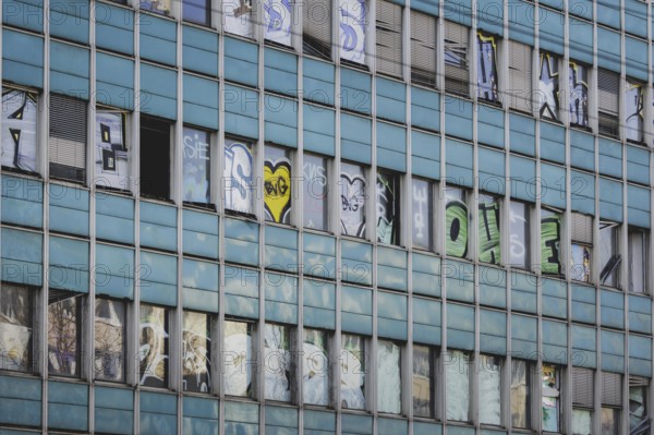 The logo of Berlin's public transport company BVG appears as graffiti on an empty office building
