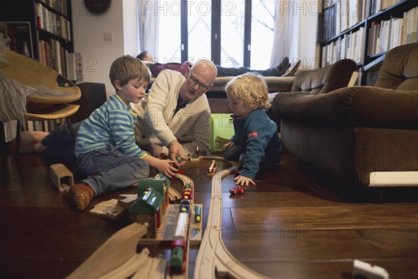 Playing children, two and four years old and their grandfather, in the family, Bonn, 24.12.2023. In